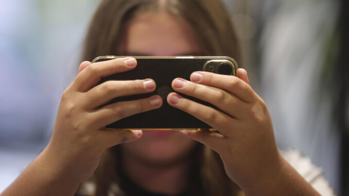 Una chica consulta su teléfono móvil, en una fotografía de archivo. EFE/ J.M. García
