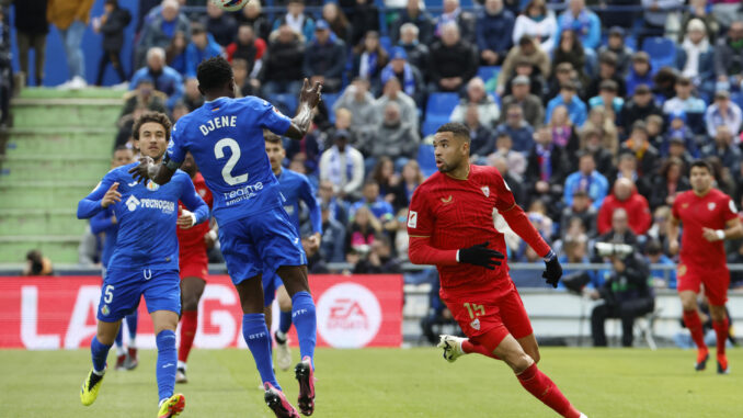 El jugador del Getafe Djene (2i) disputa el balón con Youssef En-Nesyri, del Sevilla FC, durante el partido correspondiente a la jornada 30 de LaLiga que disputaron ambos equipos este sábado en el Estadio Coliseum. EFE/ Zipi
