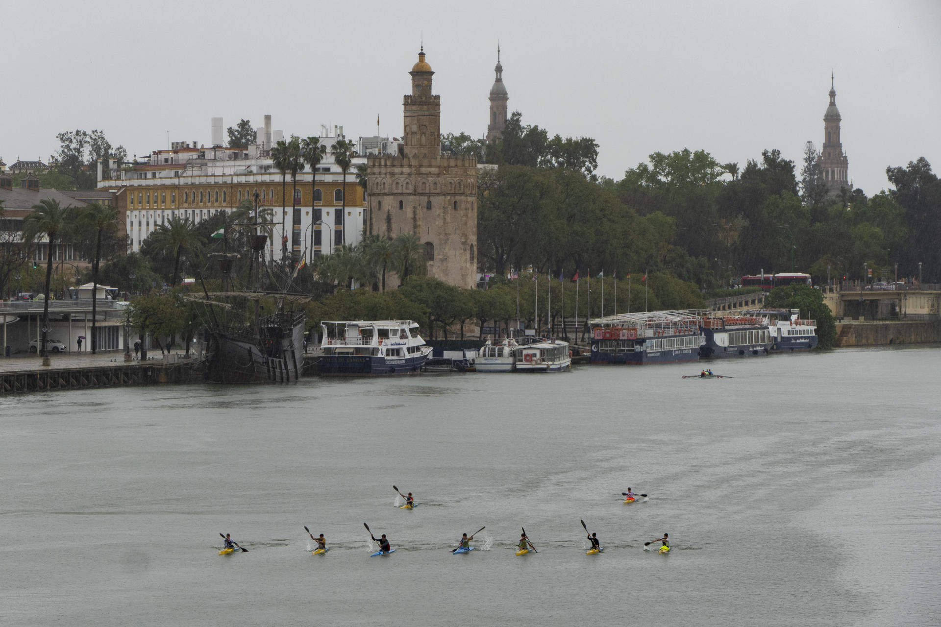 Piragüistas navegan por el río Guadiana ante la Torre del Oro en Sevilla, este domingo. Andalucía ha puesto este domingo punto y final a una Semana Santa pasada por agua que, si bien ha sido de las peores que se recuerdan para los cofrades, se ha tornado de las más beneficiosas para el campo, ayudando a paliar una situación de sequía preocupante. Este Domingo de Resurrección ha vuelto a ser una jornada en blanco para esa Andalucía cofrade que durante siete días ha mirado al cielo con desesperanza y ha asumido con resignación que la lluvia, más que necesaria, ha dado al traste con las ilusiones de todo un año de espera. EFE/ David Arjona
