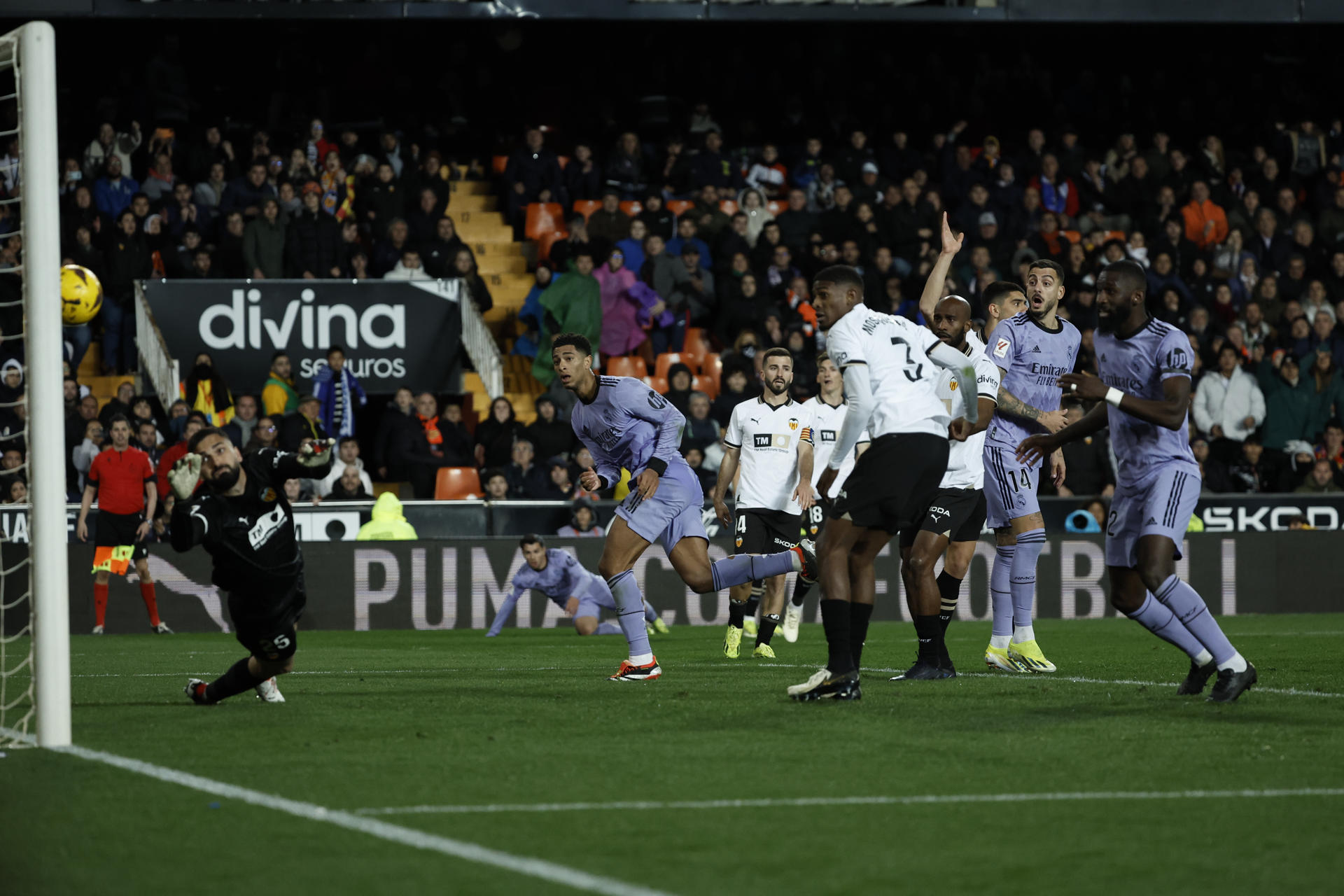 El centrocampista inglés del Real Madrid Jude Bellingham (2i) marca el gol que ha sido anulado en el último momento del partido correspondiente a la jornada 27 de Primera División que Valencia y Real Madrid disputaron en el estadio de Mestalla, en Valencia. EFE / Biel Aliño
