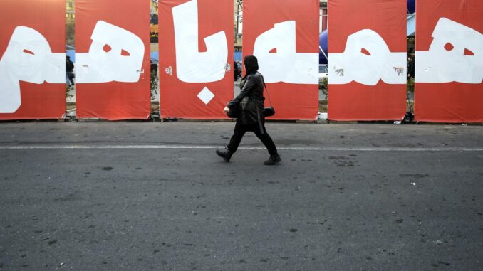 Una mujer iraní pasa junto a una enorme pancarta que dice en persa "Todos juntos por la patria" en una calle de Teherán, Irán, el 4 de marzo de 2024. Según la agencia de noticias iraní IRNA, que citó al portavoz de la sede electoral de Irán, Mohsen Eslami, los resultados para 231 escaños de 290 en el parlamento y 72 escaños en la Asamblea de Expertos se finalizaron tres días después de las elecciones. Las elecciones parlamentarias de Irán se celebraron el 1 de marzo de 2024 y se espera que la segunda vuelta se celebre en mayo de 2024. (Elecciones, Teherán) EFE/EPA/ABEDIN TAHERKENAREH
