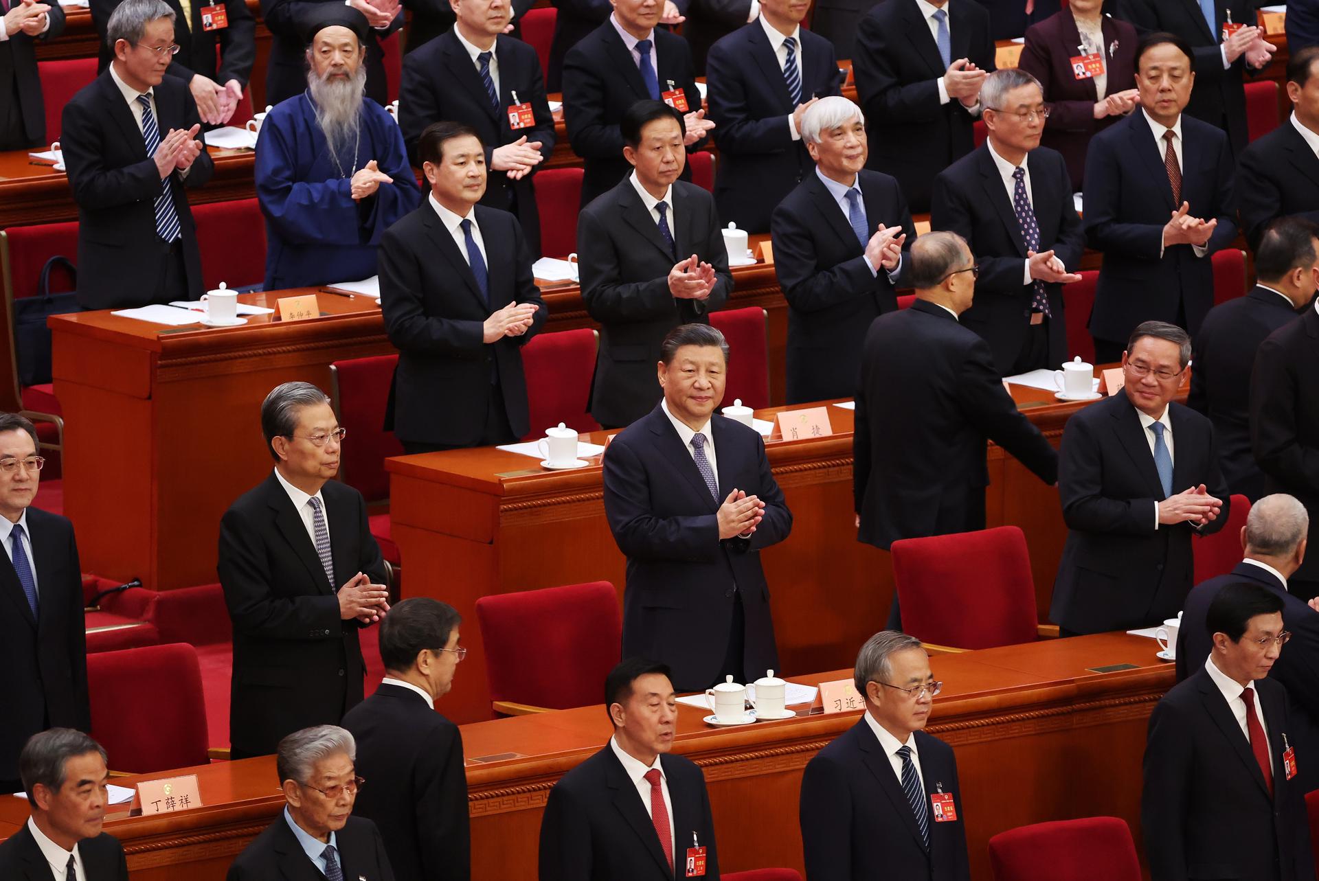 El presidente chino, Xi Jinping (C), y el primer ministro, Li Qiang (segunda fila D) y otros delegados aplauden durante la ceremonia de apertura de la sesión de la 14ª Conferencia Consultiva Política del Pueblo Chino en Pekín. EFE/EPA/WU HAO
