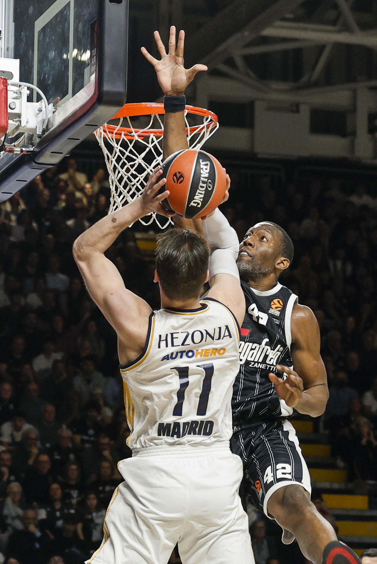 El pívot estadounidense del Virtus Bolonia Bryant Dunston (d) intenta taponar al alero croata del Real Madrid Mario Hezonja en el partido de Euroliga que se disputa este viernes en el Virtus Segafredo Arena de Bolonia, Italia. EFE/ Elisabetta Baracchi
