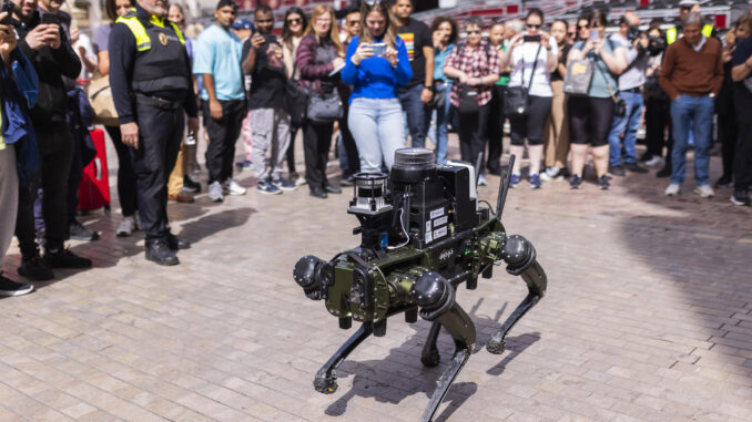 Agentes de la Policía Local de Málaga realizan una demostración práctica este martes en la calle Marqués de Larios de la capital malagueña de un robots cuadrúpedo que ha diseñado la Universidad (UMA) y que puede patrullar con los municipales. EFE/Carlos Díaz
