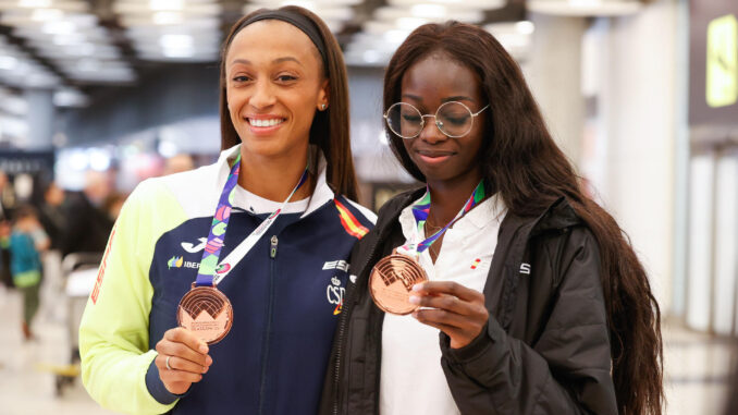 Ana Peleteiro (i), con su bronce en triple salto, y Fátima Diame, también en el tercer cajón de longitud, posan con las medallas durante la llegada del equipo español de atletismo de los Mundiales Glasgow este lunes, en Madrid. EFE/ J P Gandul
