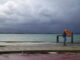 Una persona camina junto al mar con paraguas durante una jornada lluviosa este domingo, en Santander. EFE/Román G. Aguilera