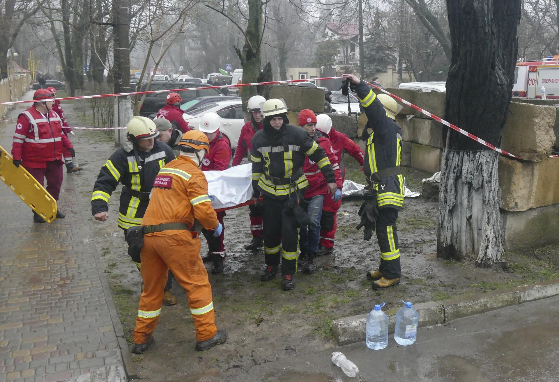 Rescatistas ucranianos transportan el cuerpo de su colega muerto cerca del lugar de un ataque con cohetes rusos en la ciudad sureña de Odesa, Ucrania, 15 de marzo de 2024. Después de que los rescatistas llegaron al lugar del ataque contra una infraestructura civil, el lugar fue alcanzado por un segundo cohete, matando al menos a un rescatista. Al menos 16 personas murieron y otras 53 resultaron heridas tras un doble ataque ruso con cohetes contra un objeto de infraestructura civil y edificios privados a su alrededor en Odesa, según un informe del Servicio Estatal de Emergencia de Ucrania. Las tropas rusas entraron en territorio ucraniano en febrero de 2022, iniciando un conflicto que ha provocado destrucción y una crisis humanitaria. (Rusia, Ucrania) EFE/EPA/IGOR TKACHENKO
