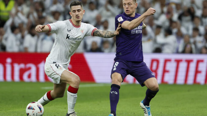 El centrocampista alemán del Real Madrid Toni Kroos (d) lucha con Oihan Sancet, del Athletic de Bilbao, durante el partido de la jornada 30 de LaLiga en el estadio Santiago Bernabéu, en Madrid. EFE/Mariscal
