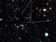 Imagen del telescopio espacial James Webb (JWST) del luminoso cuásar J1148+5251, un agujero negro supermasivo activo extremadamente raro de 10.000 millones de masas solares. La luz del cuásar, una fuente anaranjada similar a una estrella con seis claros picos de difracción, fue emitida hace 13.000 millones de años. 
Simultáneamente, la imagen captó pequeños objetos rojos puntiformes. Al igual que el cuásar J1148+5251, la luz de estos objetos (que en estos casos se emitió hace 12.500 millones de años) también está alimentada por agujeros negros supermasivos. Crédito: © NASA, ESA, CSA, J. Matthee (ISTA), R. Mackenzie (ETH Zúrich), D. Kashino (Observatorio Nacional de Japón), S. Lilly (ETH Zúrich)