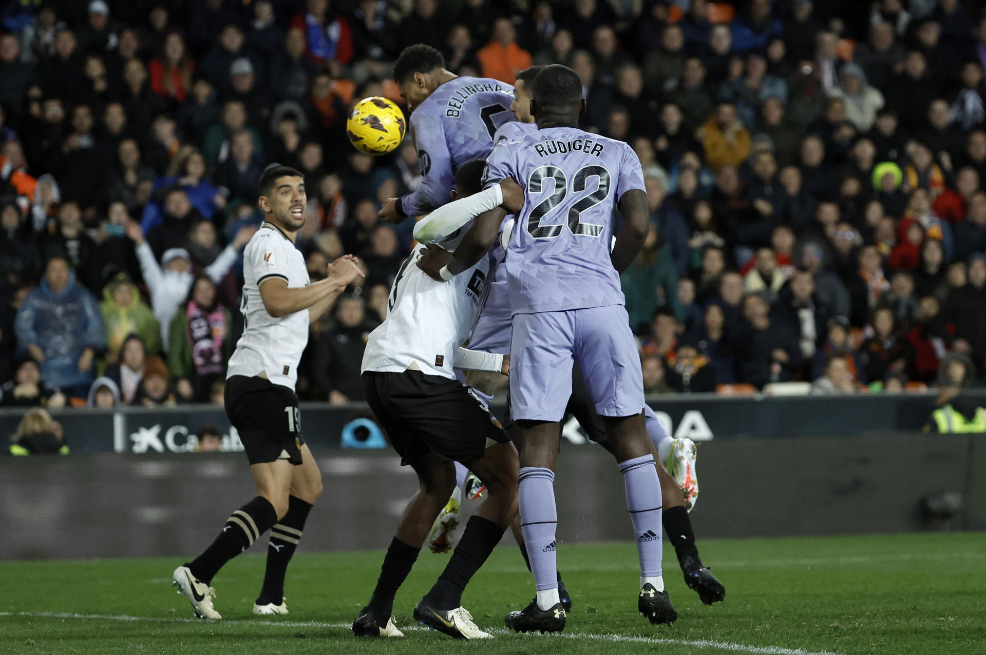 El centrocampista del Real Madrid, Jude Bellingham (2d), remata el balón en la jugada del gol que no ha subido al marcador al pitar el colegiado el final del partido durante el encuentro correspondiente a la jornada 27 de Primera División que Valencia y Real Madrid disputaron en el estadio de Mestalla, en Valencia. EFE / Biel Aliño.
