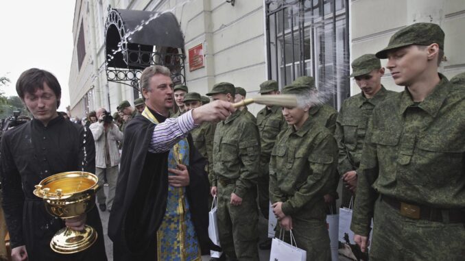 Un sacerdote bendice a jóvenes reclutas rusos en una imagen de archivo. EFE/Anatoly Maltsev
