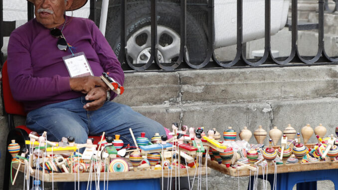 Un hombre vende artesanías el lunes en una calle de la Ciudad de México (México). EFE/ Mario Guzmán
