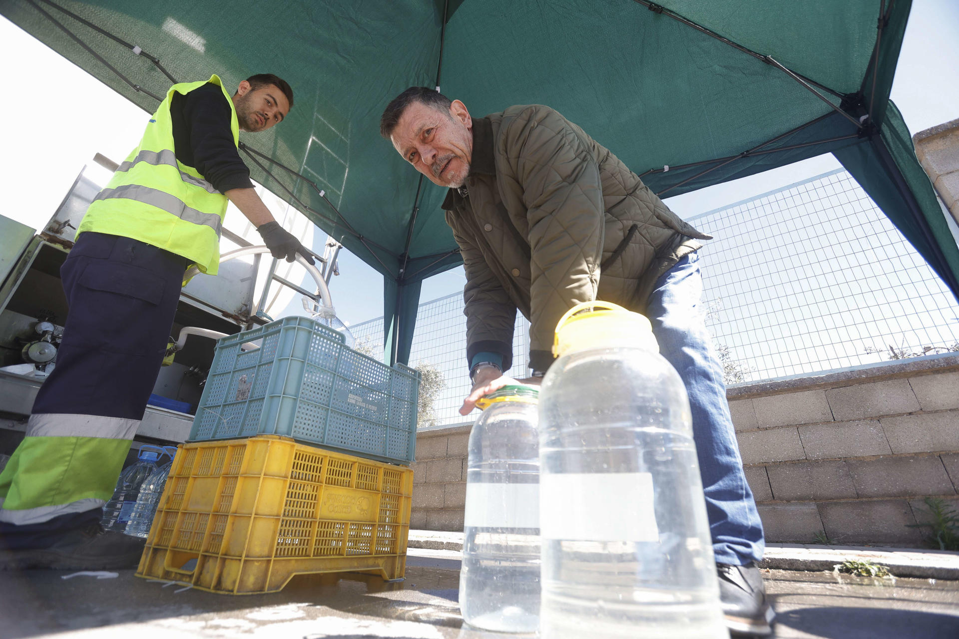 Vecinos de Pozoblanco durante el reparto de agua con camión cisterna. Las últimas lluvias de Semana Santa han llenado los pantanos andaluces pero en el norte de Córdoba cerca de 80.000 vecinos siguen sin agua potable en sus grifos, una situación que se prolonga ya durante un año y que está a la espera del resultado positivo de los análisis que se están efectuando para acelerar el proceso que devuelva la normalidad al abastecimiento de la población. EFE/Salas
