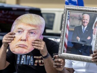 Fotografía de archivo donde se aprecia dos personas con un retrato de Biden y una máscara de Trump. EFE/EPA/CRISTOBAL HERRERA-ULASHKEVICH