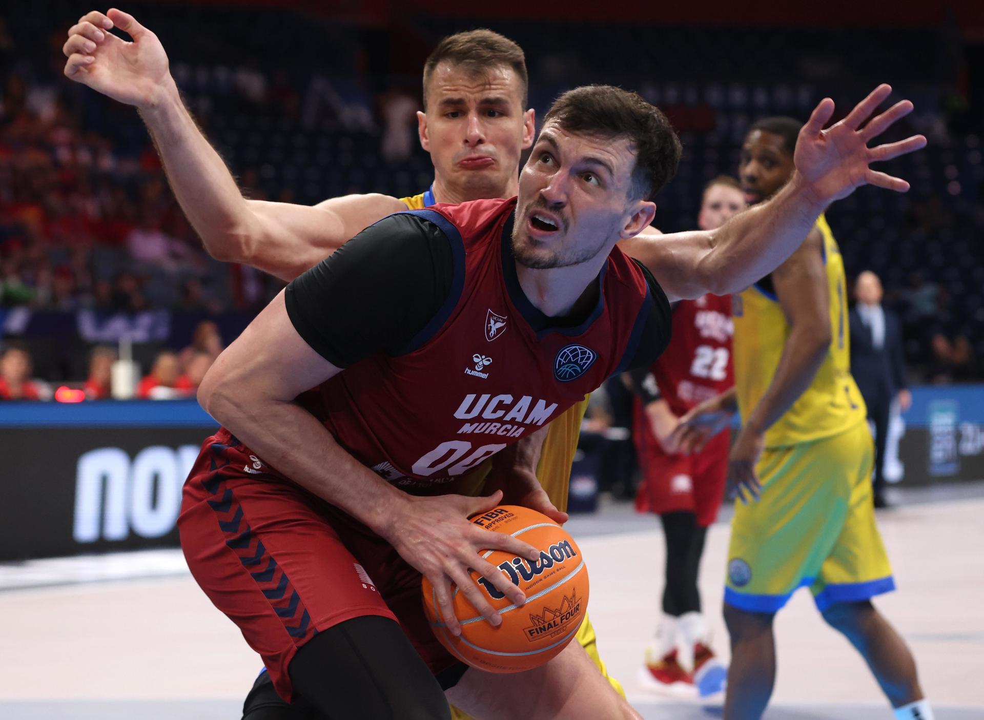 El jugador de Murcia Rodions Kurucs (d) en acció ante Nemanja Dangubic (I), del Peristeri, durante el partido por el tercer puesto de la FIBA Champions League Final Four jugado en Belgrado, Serbia. EFE/EPA/ANDREJ CUKIC

