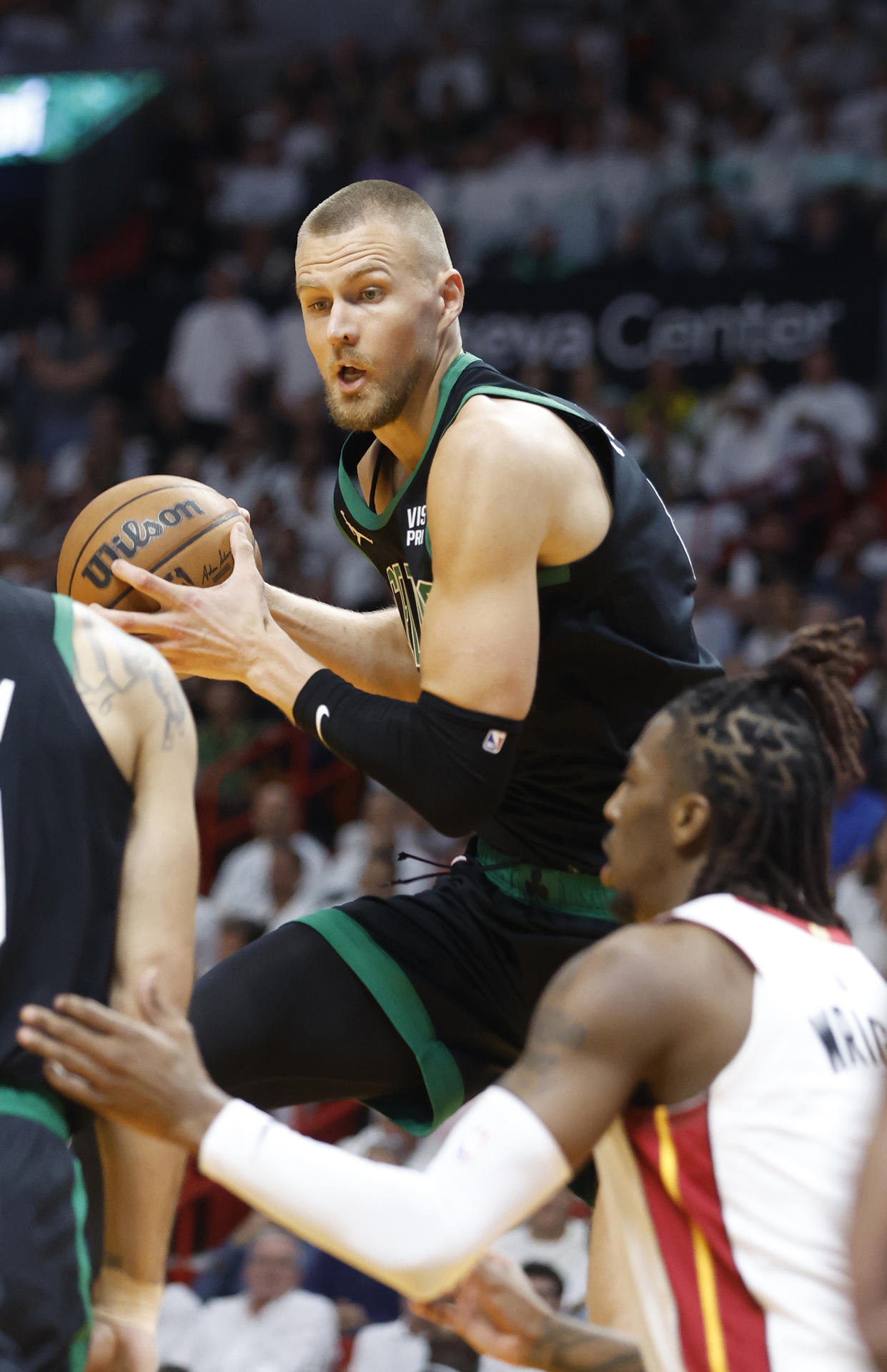 El ala-pívot letón de los Celtics, Kristaps Porzingis (i), disputa un balón con Delon Wright de los Heat este lunes, en el partido ganado por la franquicia de Boston en el Kaseya Center (Florida). EFE/ Rhona Wise
