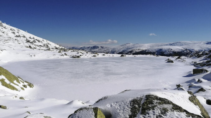 Vista de la Laguna de Peñalara helada, con la Cuerda Larga al fondo. EFE/Pepe Ceballos
