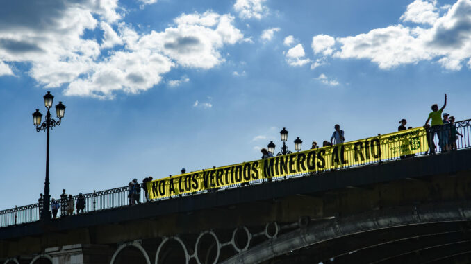 Pancarta desplegada en el Puente de Triana de Sevilla durante una concentración convocada por Ecologistas en Acción y Greenpeace contra los vertidos de aguas tóxicas al Guadalquivir procedentes de la Mina de Aznalcóllar, que ha tenido lugar en el Muelle de la Sal de la capital andaluza. EFE/ Raúl Caro
