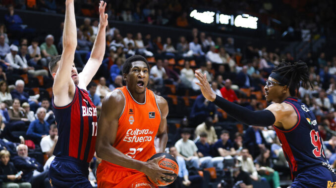 El ala pívot nigeriano del Baskonia, Chima Moneke (d), y su compañero de equipo, Nikos Rogkavopoulos (i), intentan detener a Alpha Kaba (c), del Valencia durante el partido de Liga Endesa de baloncesto en la Fuente de San Luis. EFE/ Miguel Ángel Polo
