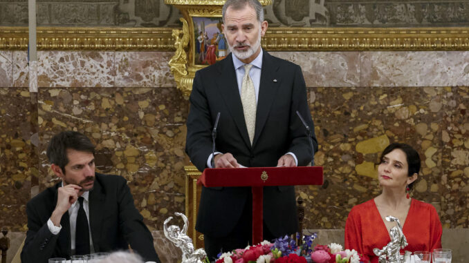 El rey Felipe VI pronuncia un discurso, flanqueado por el ministro de Cultura, Ernest Urtasun (i), y por la presidenta de la comunidad de Madrid, Isabel Díaz Ayuso, durante el almuerzo que los reyes han ofrecido a una representación del mundo de las letras un día después de la entrega del citado galardón, este miércoles en el palacio de El Pardo en Madrid. EFE/ Daniel González / POOL
