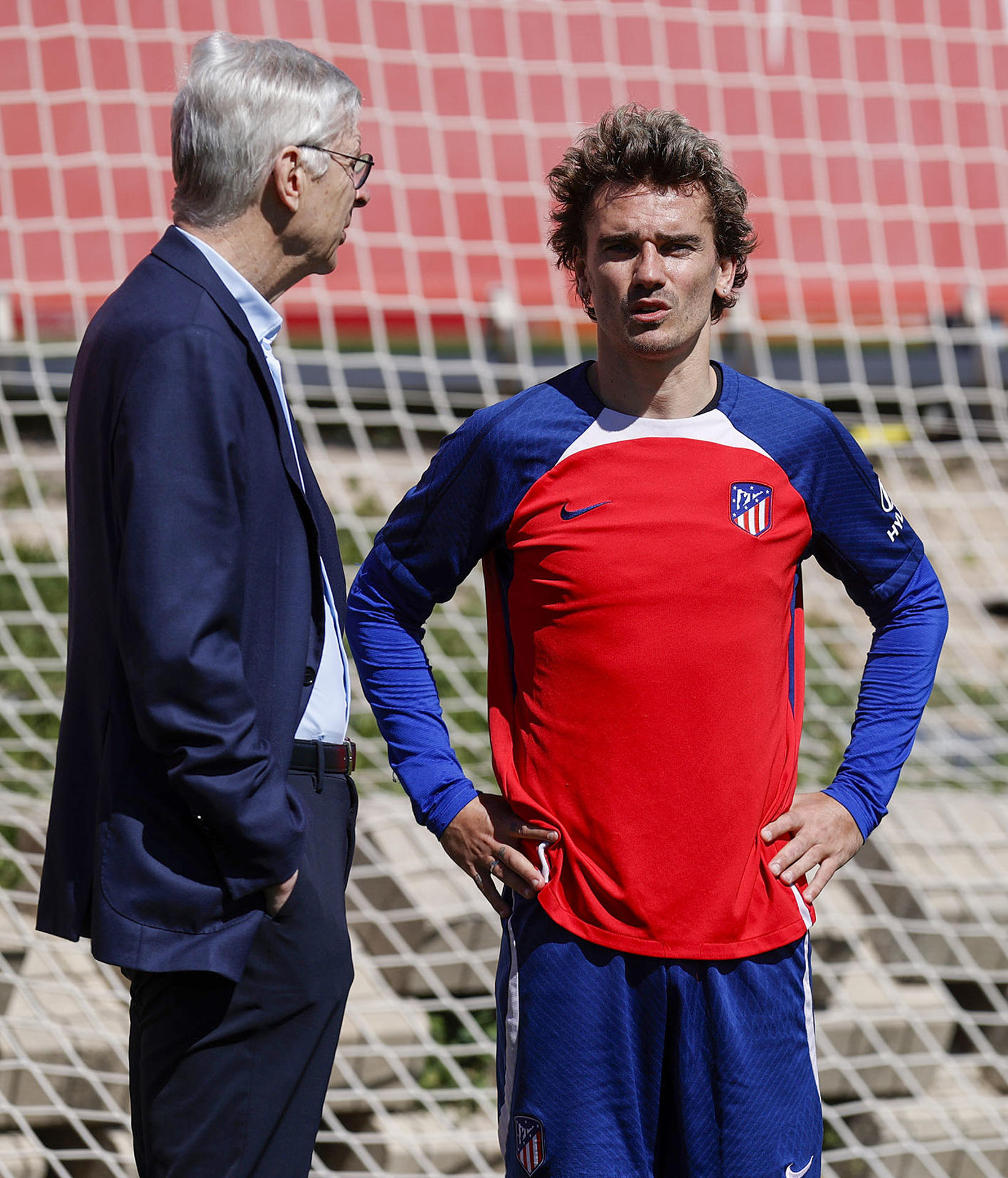 El delantero francés del Atlético de Madrid, Antoine Griezmann (d), charla con Arsène Wenger, director de desarrollo de FIFA, durante el entrenamiento de este jueves en la Ciudad Deportiva Wanda en Majadahonda, Madrid. EFE/AtléticodeMadrid.com
