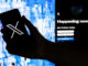 Fotografía de archivo donde se muestra a un usuario mientras sostiene un teléfono móvil que muestra el logotipo de la página de la red social 'X'. EFE/Etienne Laurent