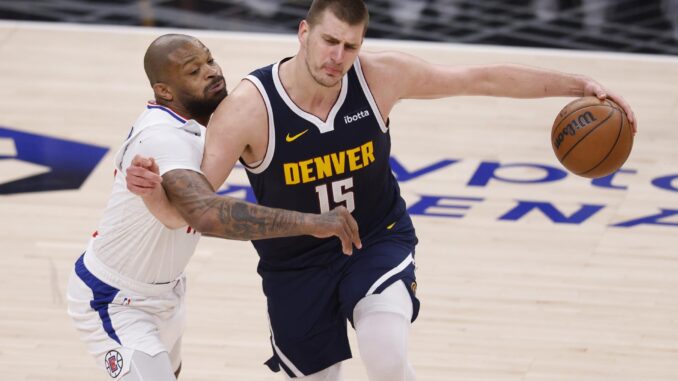 El jugador de Denver Nuggets Nikola Jokic (d) intenta mantener la posesión de la pelota mientras es custodiado por el jugador de Los Angeles Clippers P.J. Tucker (i) durante el tercer cuarto del partido de baloncesto de la NBA entre los Denver Nuggets y Los Angeles Clippers en Los Ángeles, California, EE. UU. EFE/EPA/CAROLINE BREHMAN
