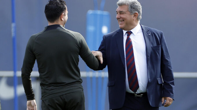 El presidente del FC Barcelona, Joan Laporta (d) saluda al técnico azulgrana, Xavi Hernández (i) en un entrenamiento.EFE/ Alberto Estévez
