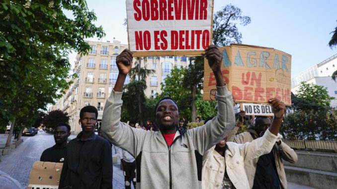 Integrantes de entidades sociales impulsoras de la iniciativa legislativa popular avalada por casi 700.000 firmas para aprobar una regularización extraordinaria para cerca de medio millón de extranjeros que viven en España sin papeles se manifiestan durante el debate en el pleno del Congreso de los Diputados, este martes en Madrid. EFE/ Borja Sanchez-Trillo
