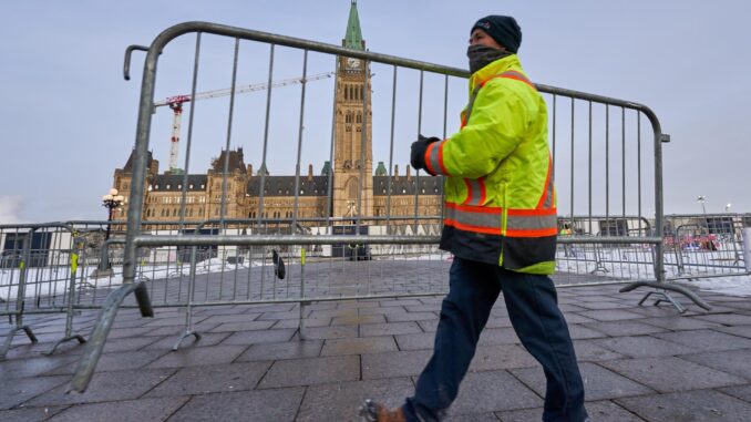 Un trabajador mueve una valla frente a la colina del parlamento, en una fotografía de archivo. EFE/EPA/Andre Pichette
