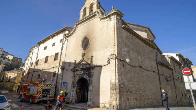 Los bomberos actúan en la puerta principal de la iglesia del convento de las Concepcionistas de Cuenca. EFE/ José del Olmo
