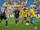 El centrocampista de Las Palmas Enzo Loiodice (c-d) disputa un balón con el delantero del Betis Ayoze Pérez (c-i) durante el encuentro correspondiente a la jornada 36 de LaLiga entre U.D. Las Palmas y Real Betis Balompié, este jueves en el Estadio de Gran Canaria. EFE/ Ángel Medina G.