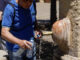 Una persona rellena una botella de agua en la fuente del Patio de los Naranjos este miércoles, en Córdoba. EFE/ Rafa Alcaide