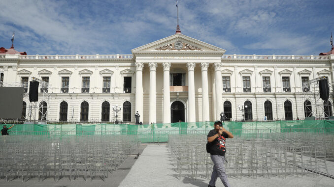 Un hombre camina frente al Palacio Nacional mientras se realizan los preparativos para la ceremonia de investidura del segundo mandato de Nayib Bukele, este jueves en San Salvador (El Salvador). EFE/ Rodrigo Sura
