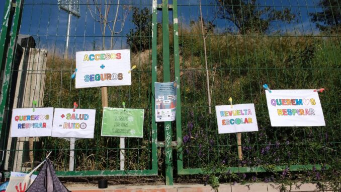 Vista de los carteles colgados en la valla de un colegio para reivindicar espacios escolares seguros sin contaminación. EFE/Ana Márquez
