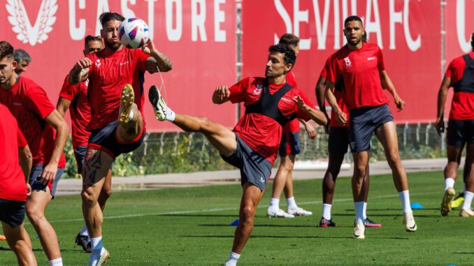 El jugador del Sevilla Jesús Navas (c), junto a su compañero Sergio Ramos (i) disputando un balón durante el entrenamiento del equipo en la ciudad deportiva. EFE/ Julio Muñoz
