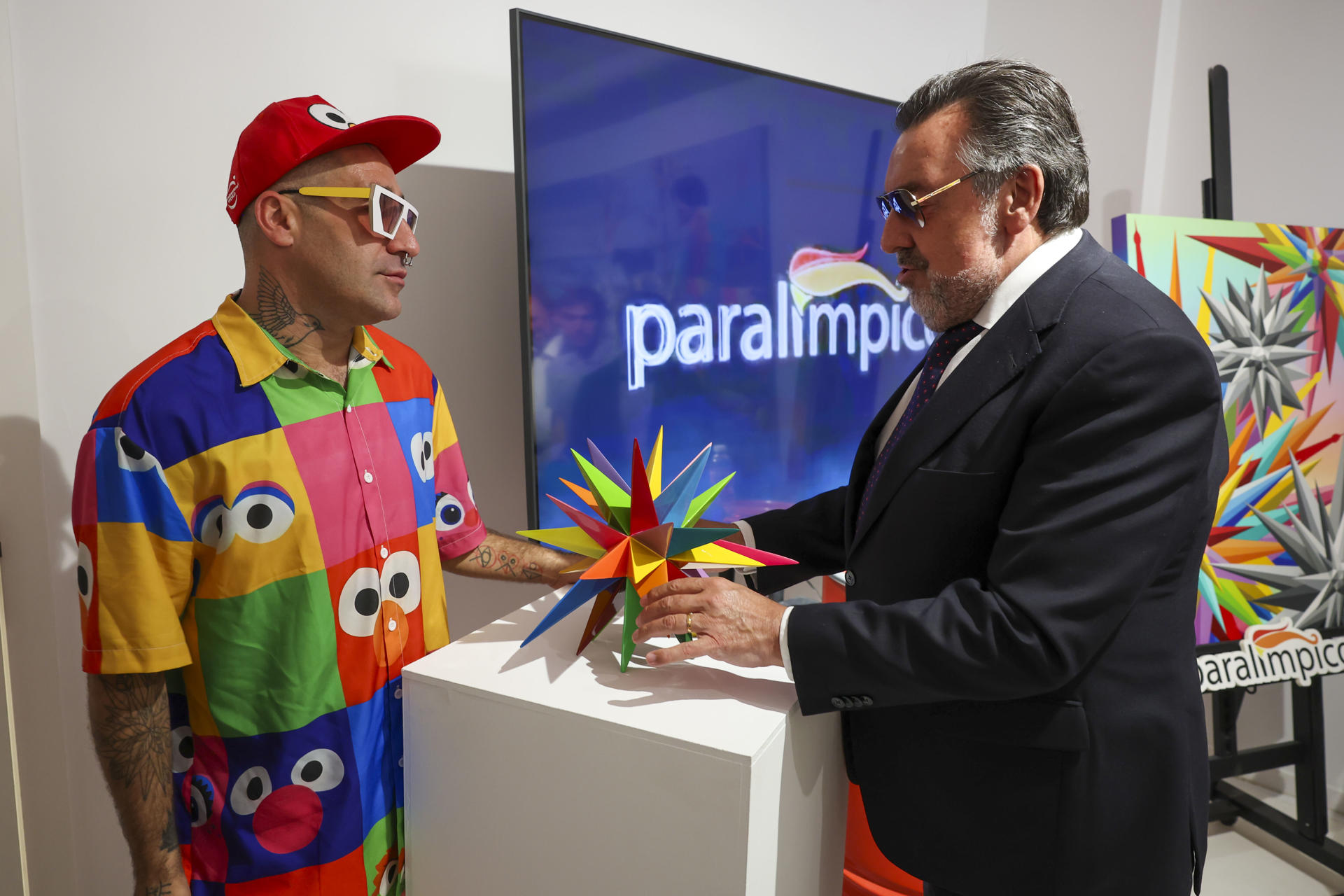 El artista Okuda (i) entrega al presidente del Comité Paralímpico Español, Miguel Carballeda (d), la "Estrella del Kaos", en el taller 'Factoría de sueños' de Okuda en el madrileño barrio de Usera. EFE/Kiko Huesca
