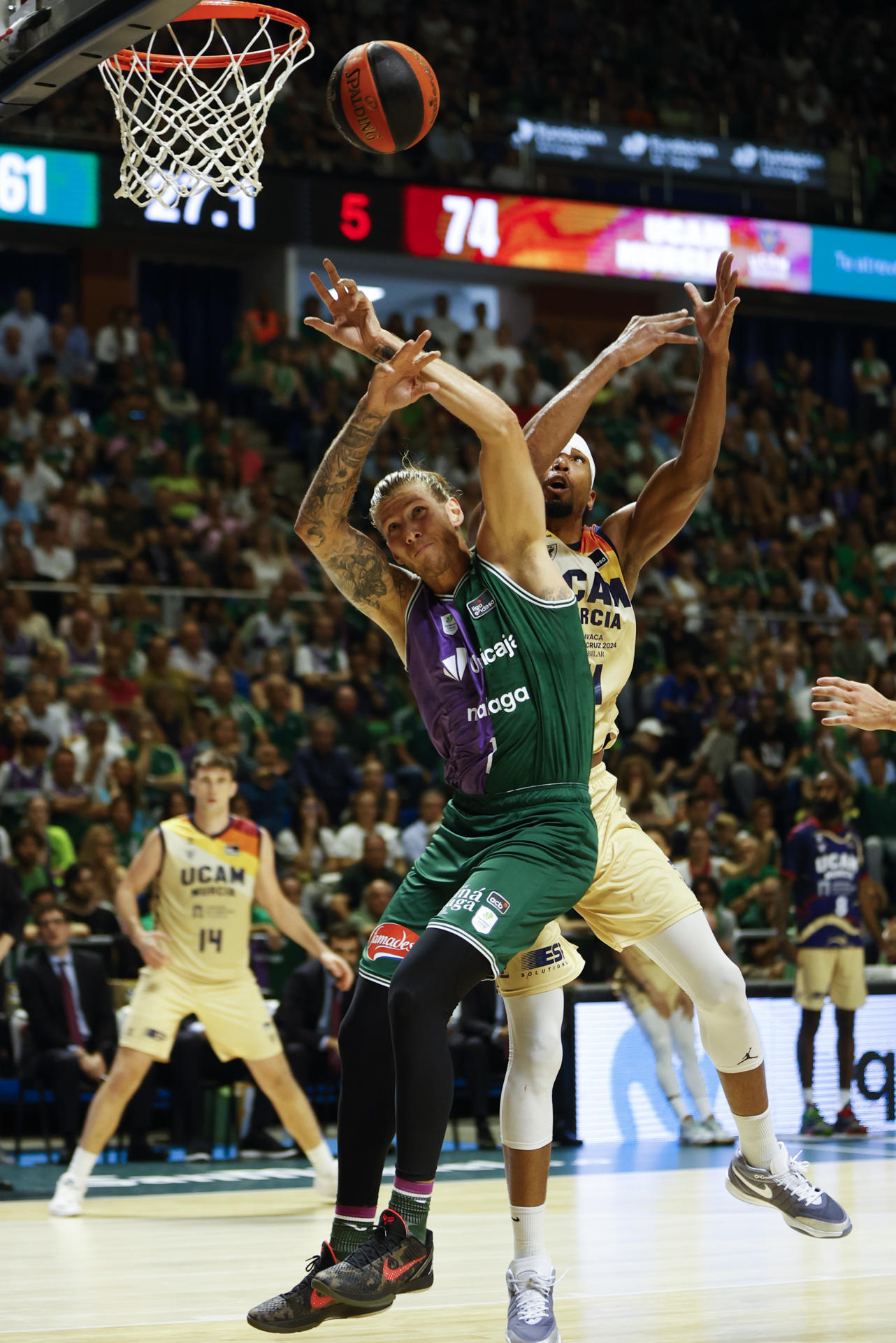 El pívot de UCAM Yannis Morin (d) pelea un balón con Dylan Osetkowski, de Unicaja, durante el segundo partido de la semifinal de la Liga Endesa de baloncesto que Unicaja Málaga y UCAM Murcia disputan este jueves en el Palacio de Deportes José María Martín Carpena. EFE/Jorge Zapata
