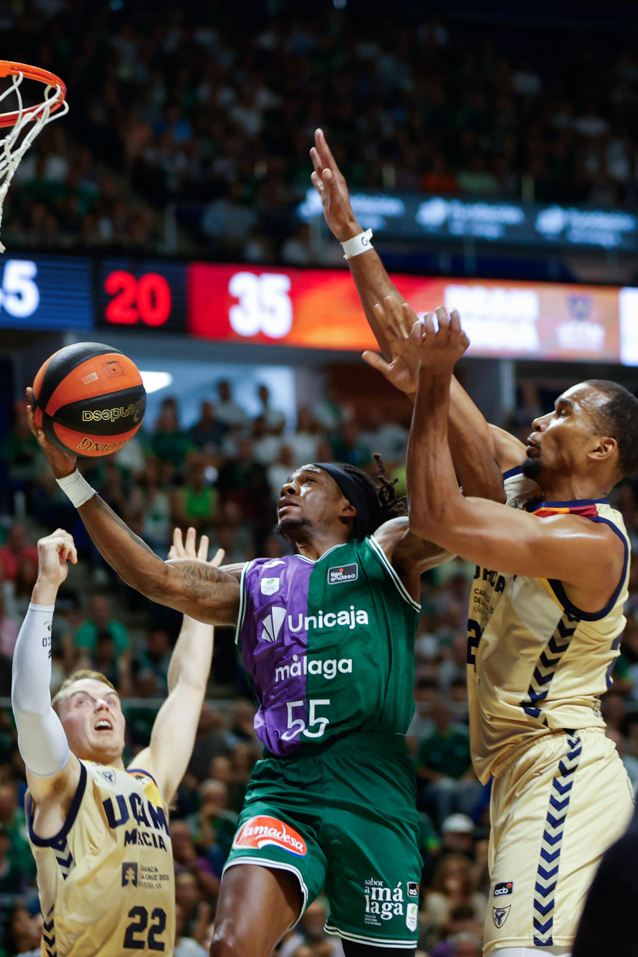 El base de Unicaja Kendrick Perry (c) entra a canasta ante Ludde Hahanson (i) y Yannis Morin, ambos del UCAM, durante el segundo partido de la semifinal de la Liga Endesa de baloncesto que Unicaja Málaga y UCAM Murcia disputan este jueves en el Palacio de Deportes José María Martín Carpena. EFE/Jorge Zapata
