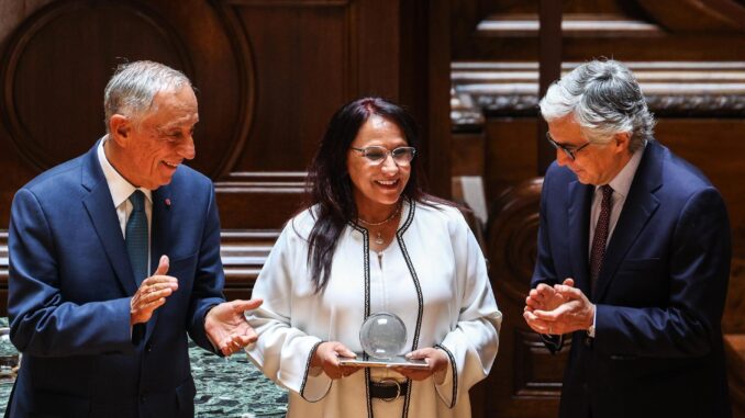 El Presidente portugués Marcelo Rebelo de Sousa (izquierda) y el Presidente de la Asamblea José Pedro Aguiar Branco (derecha) aplauden la adjudicación de la Presidenta del Consejo Nacional de Derechos Humanos de Marruecos, Amina Bouayach (Centro), con el premio Norte/Sur durante la ceremonia celebrada en el Parlamento portugués en Lisboa, Portugal, el 21 de mayo de 2024. El Premio Norte-Sur del Consejo de Europa distingue anualmente a dos personalidades u organizaciones por su compromiso con los derechos humanos, la democracia y el Estado de derecho, y por su contribución al diálogo Norte-Sur y el fomento de la solidaridad, la interdependencia y las asociaciones. (Marruecos, Lisboa) EFE/EPA/TIAGO PETINGA
