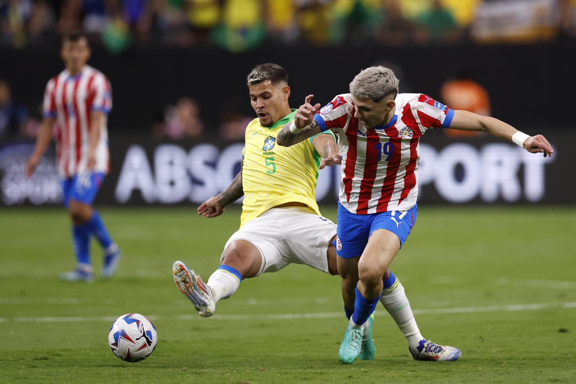 El centrocampista brasileño Bruno Guimaraes (i) patea el balón del delantero paraguayo Julio Enciso (d) durante la Copa América 2024. EFE/EPA/CAROLINE BREHMAN
