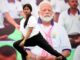 Una mujer practica yoga delante de un retrato del primer ministro indio, Narendra Modi, en el Día Internacional del Yoga, el 21 de junio de 2024. EFE/EPA/HARISH TYAGI