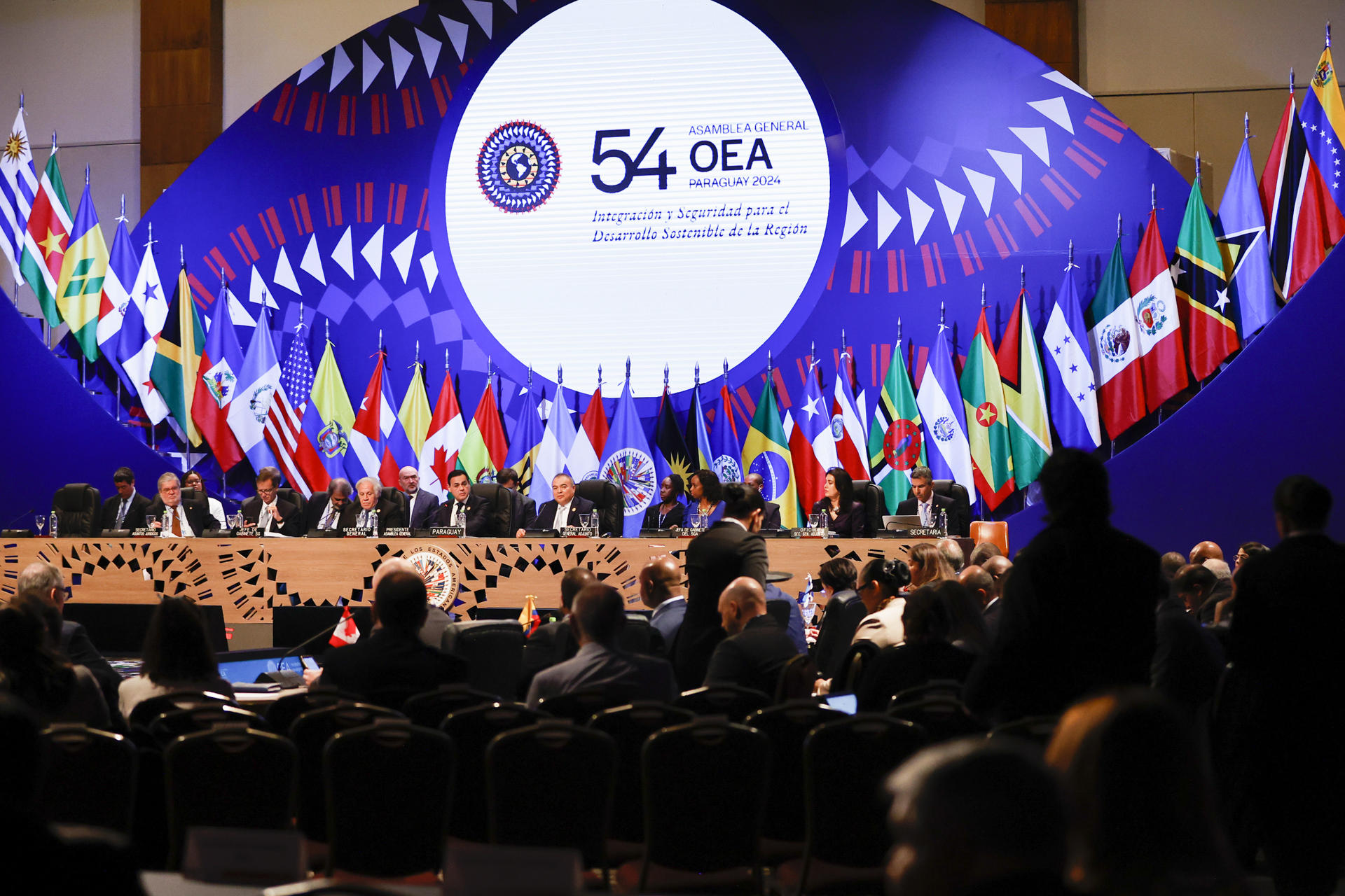 Representantes de los países miembros de la Organización de Estados Americanos (OEA) participan de la Primera Sesión Plenaria durante la 54ª Asamblea General de la OEA, en el Centro de Convenciones de la Conmebol, este jueves, en Luque (Paraguay). EFE/ Bienvenido Velasco
