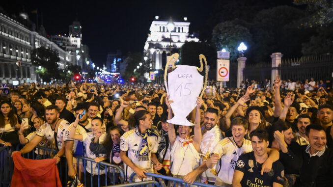 Aficionados del Real Madrid en la plaza de Cibeles celebran la Decimoquinta Copa de Europa tras imponerse 2-0 al Borussia Dortmund en la final de la Liga de Campeones. EFE/Fernando Villar

