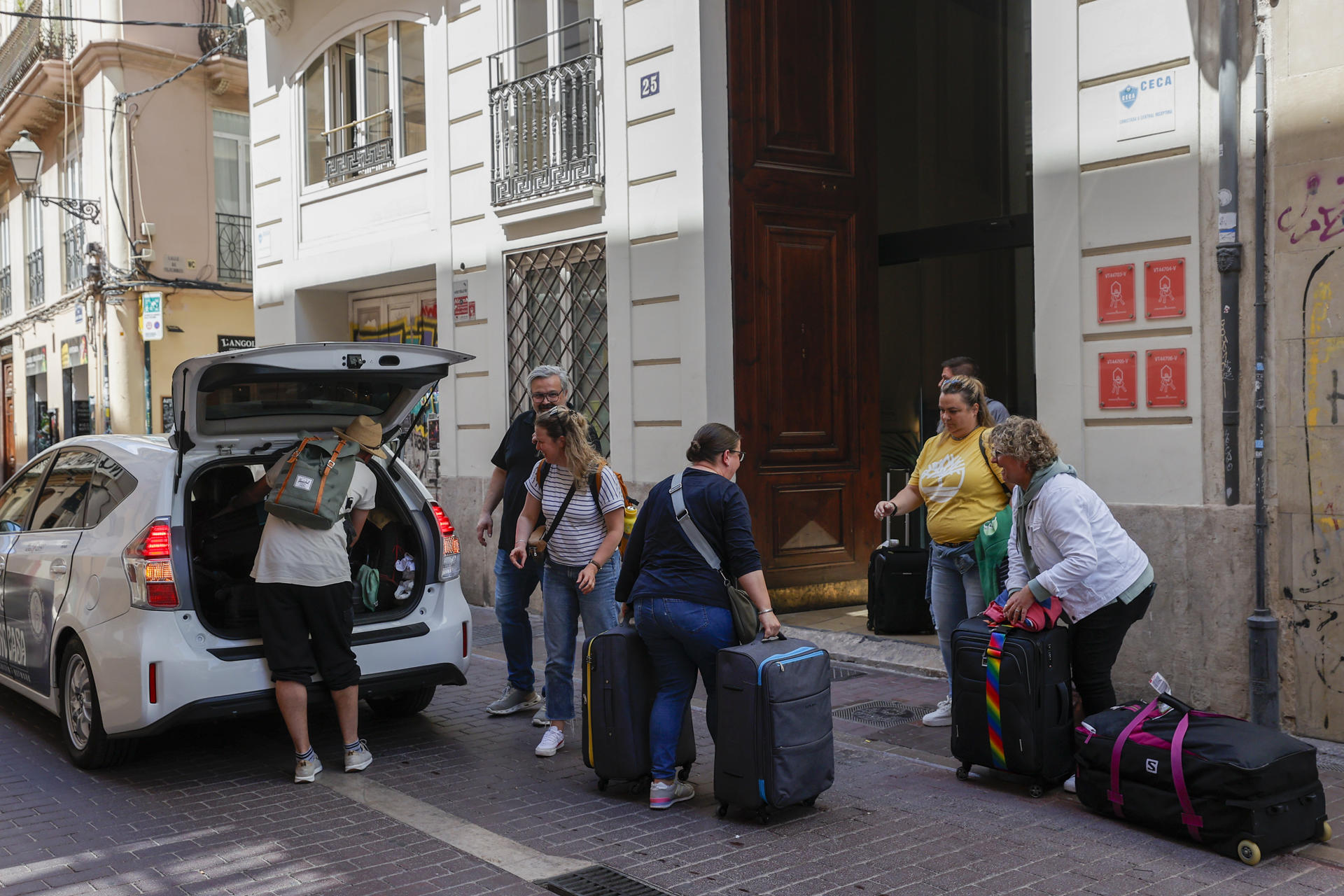 Imagen de archivo de un grupo de turistas descargando sus maletas a la entrada de unos apartamentos turísticos en Valencia.
 EFE/Manuel Bruque
