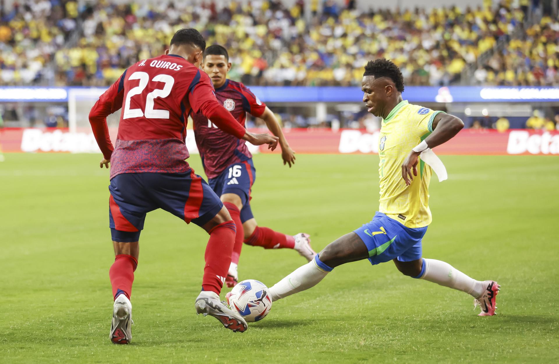 El delantero brasileño Vinicius Junior (d) intenta pasar por el defensor costarricense Haxzel Quiros (i) y el centrocampista costarricense Alejandro Bran (C) durante la segunda mitad de la CONMEBOL Copa América Partido de fútbol del grupo D 2024 entre Brasil y Costa Rica, en Inglewood, California. EFE/EPA/CAROLINE BREHMAN
