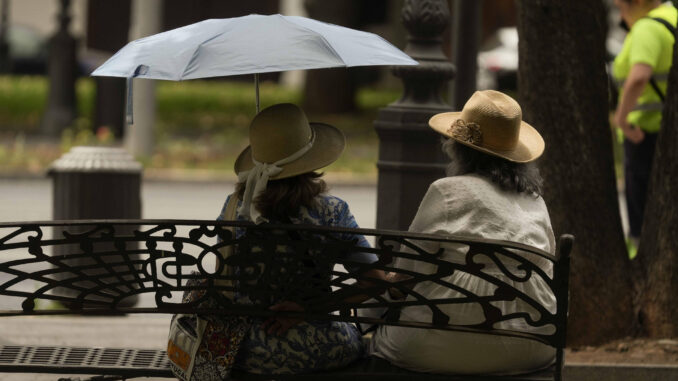 Dos mujeres se resguardan con un paraguas peste jueves en Córdoba. EFE / Rafa Alcaide
