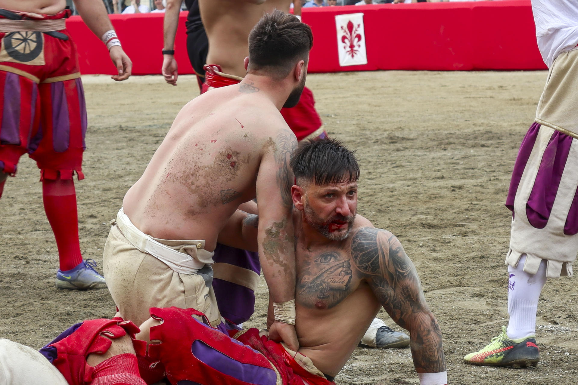 Dos 'calcianti' se enfrentan en la Plaza de la Santa Cruz de Florencia (Italia), lugar donde se celebra desde hace casi 500 años el 'Calcio Storico', un sangriento deporte que mezcla fútbol, rugby y lucha. EFE/ Miguel Salvatierra
