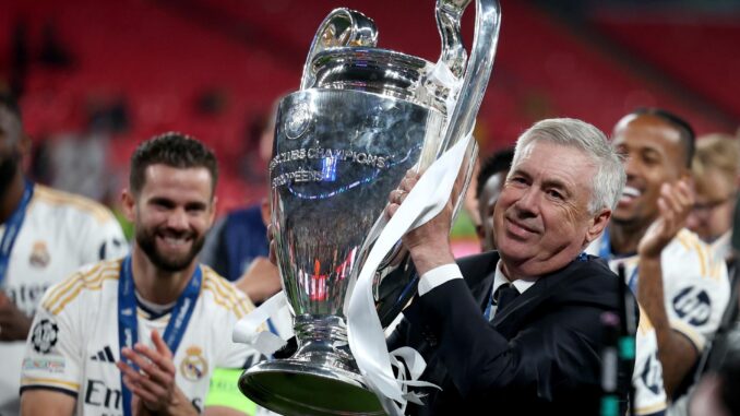 Carlo Ancelotti (3i), entrenador italiano del Real Madrid, fue registrado este sábado, 1 de junio, al levantar la copa de la Liga de Campeones de Europa, tras derrotar en la final del certamen por 0-2 al Borussia Dortmund, en Londres (Reino Unido). EFE/Neil Hall
