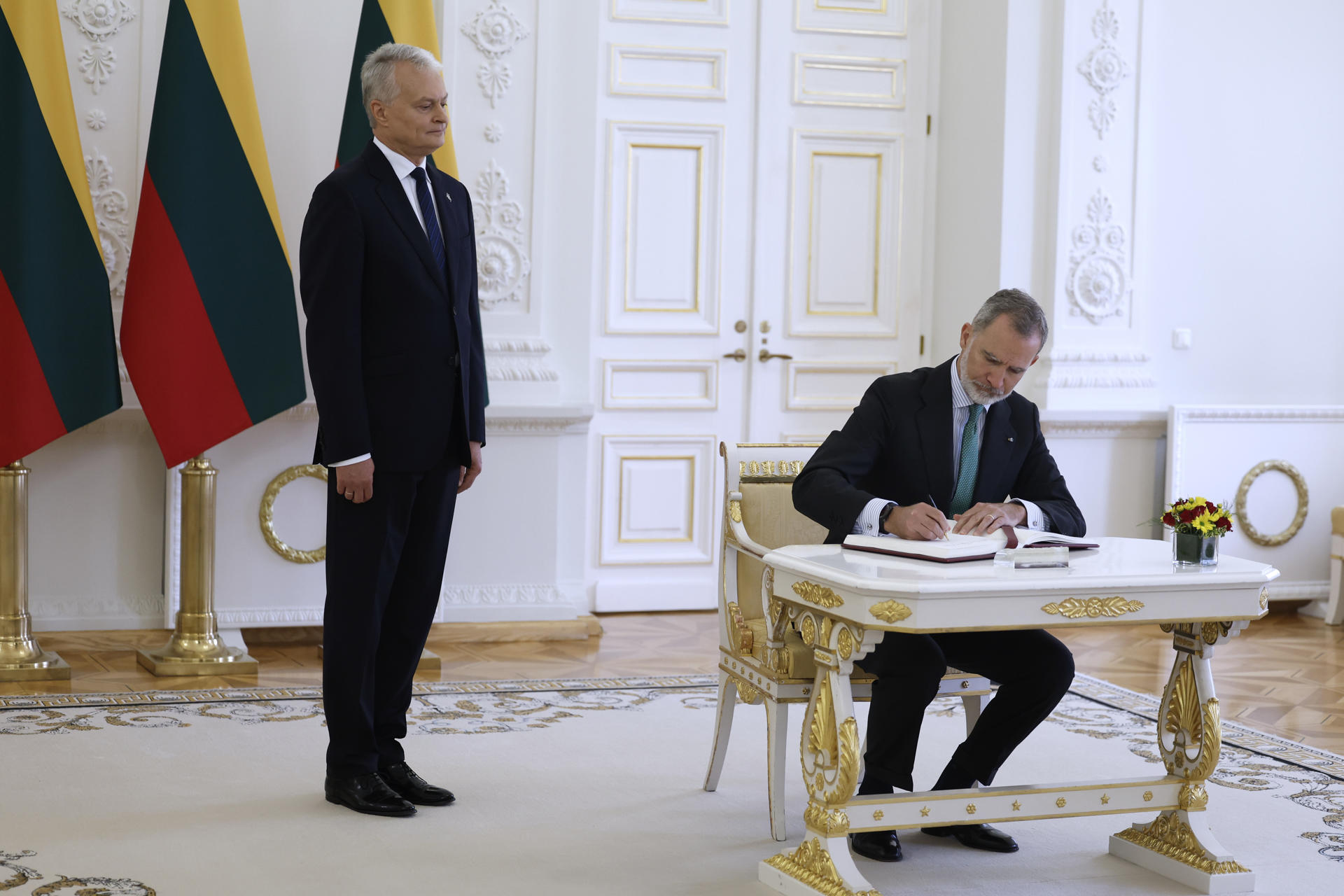 El rey de España, Felipe VI, (dch), firma en el libro de honor de autoridades durante su reunión con el presidente lituano, Gitanas Nauseda, (izq), el 24 de junio de 2024. EFE/Mariscal
